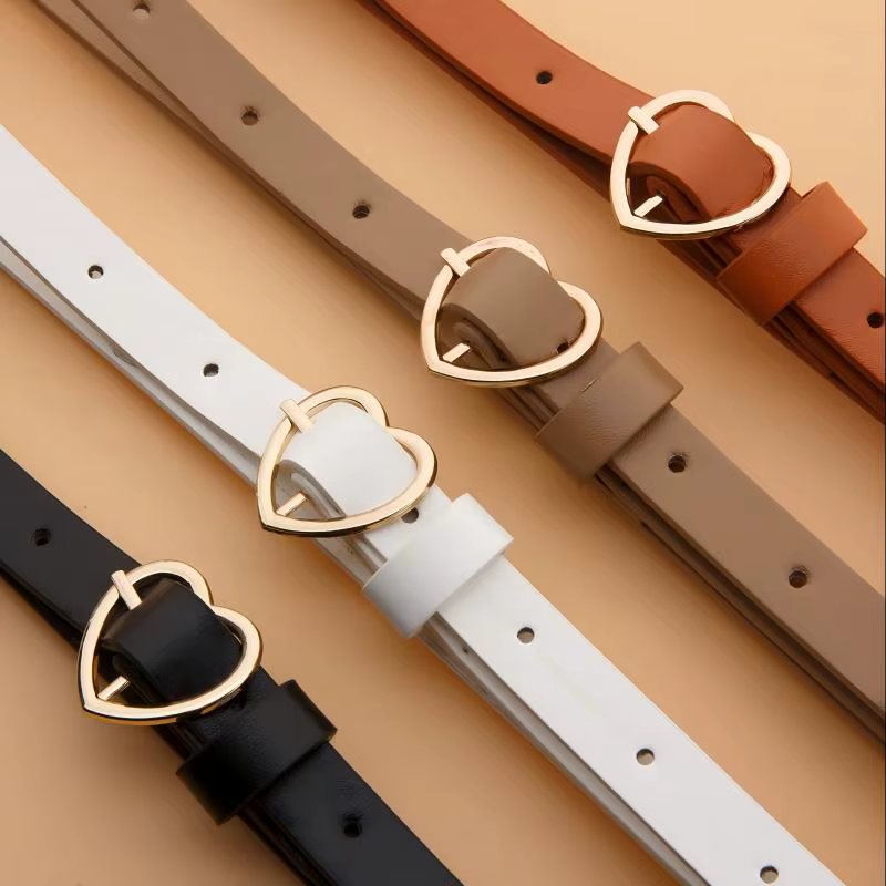Un ensemble de trois ceintures fines à boucle dorée en forme de cœur